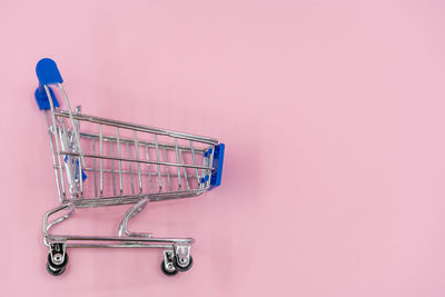 Close-up of metallic structure against pink wall