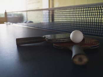 Old table tennis rackets and balls placed on table tennis