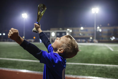 Cute boy holding trophy