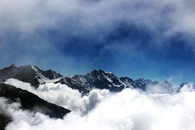 Scenic view of snow covered mountains against cloudy sky