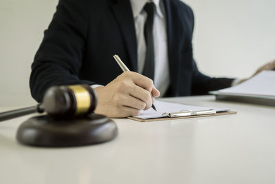 Midsection of man with umbrella on table