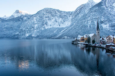 Scenic view of lake by snowcapped mountains against sky