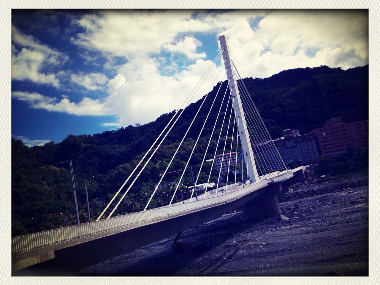 sky, mountain, transfer print, connection, built structure, architecture, transportation, bridge - man made structure, cloud - sky, cloud, the way forward, auto post production filter, engineering, cloudy, low angle view, suspension bridge, mountain range, railing, day, road