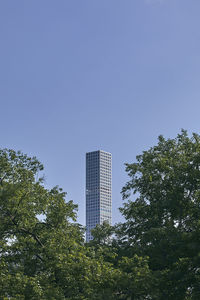 Low angle view of trees and buildings against clear sky