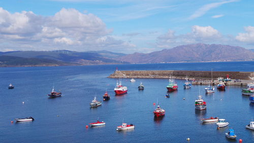 Boats in sea with mountains in background