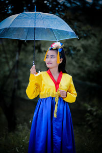 Portrait of young woman holding umbrella