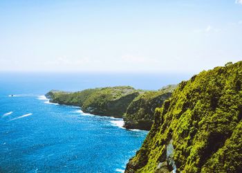 Scenic view of sea by cliff against sky