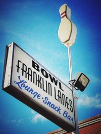 Low angle view of road sign against blue sky