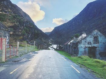 Road amidst buildings against sky