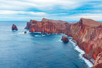 Scenic view of sea and mountains against sky