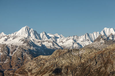 Scenic view of snowcapped mountains against clear blue sky