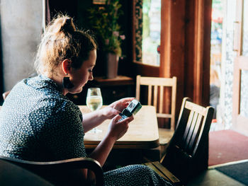 Man using mobile phone while sitting on chair