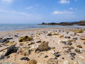 Scenic view of rocks on beach against sky