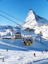 People skiing on snowcapped mountain against sky