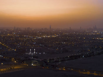 High angle view of illuminated buildings against sky at sunset