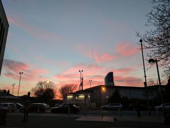 Illuminated city against sky at sunset