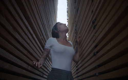 Young woman looking through wall