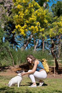 Portrait of woman with dog on field