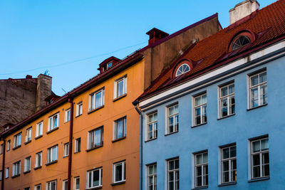 Low angle view of houses against clear blue sky