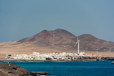 Sailboats in sea against clear blue sky