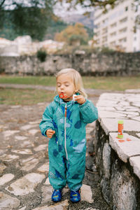 Portrait of cute boy standing on retaining wall