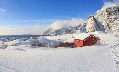 Houses on snow covered landscape against sky