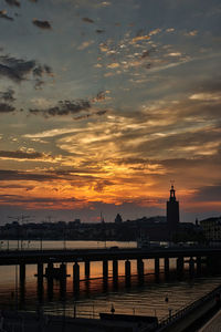 Silhouette buildings against sky during sunset