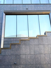 Low angle view of glass building against sky