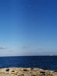 Scenic view of sea against clear blue sky