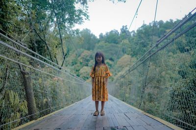A little asian girl is walking on situ gunung suspension bridge