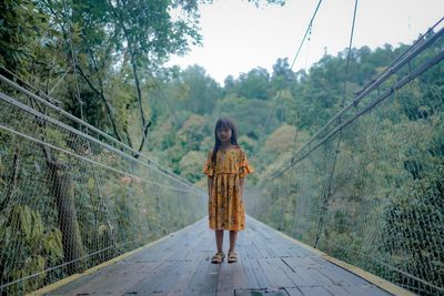 Rear view of woman walking on footbridge