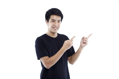 Portrait of young man standing against white background