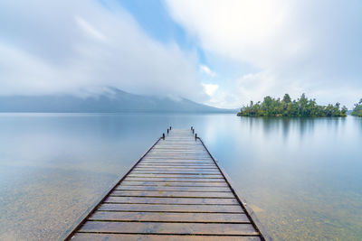 Scenic view of pier over lake against sky