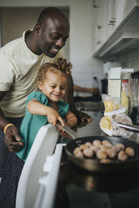 Happy girl helping father cook meal