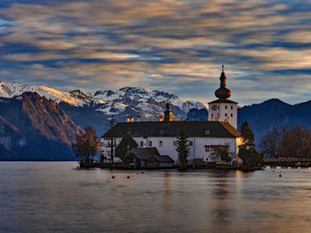 Scenic view of buildings by mountains against sky during winter