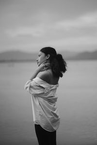 Side view of woman standing against sky