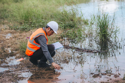 Rear view of man standing in lake