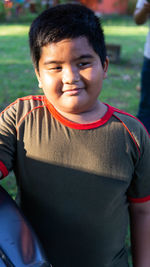 Smiling boy looking away while standing at park