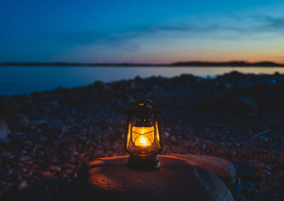 Close-up of illuminated lantern on shore