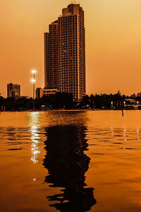 Modern buildings in city against sky during sunset