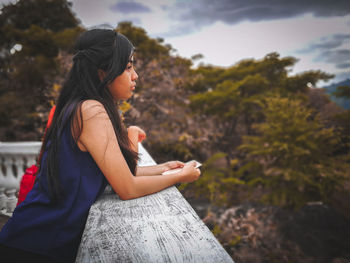 Side view of teenage girl standing at observation point