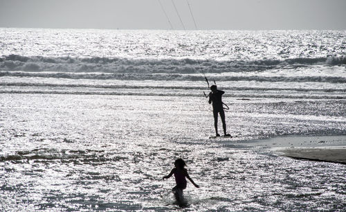 Silhouette man fishing at beach