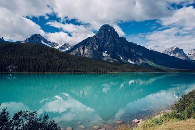 Scenic view of lake by mountains against sky