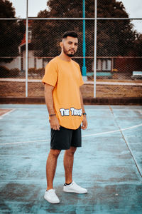 Full length of young man standing on soccer field