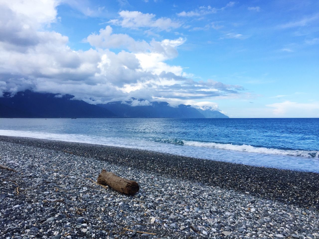 PEBBLES ON BEACH AGAINST SKY