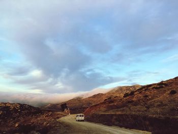 Road by mountain against sky