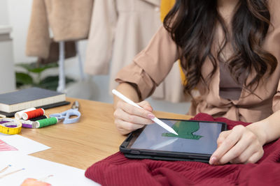 Midsection of woman writing in book