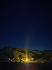 Scenic view of the mountain against the sky at night with campfire