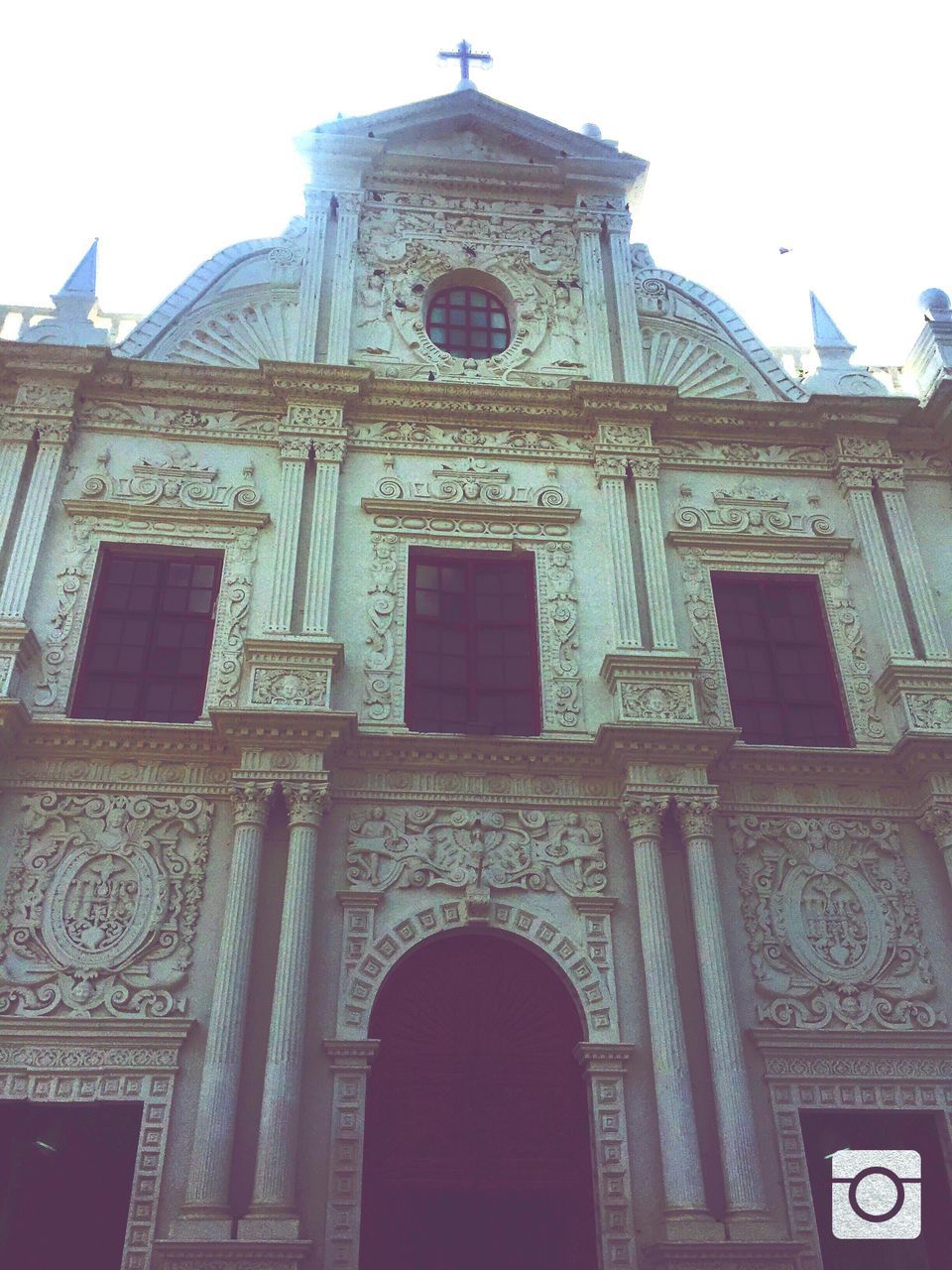 architecture, building exterior, religion, church, place of worship, built structure, low angle view, spirituality, cathedral, arch, facade, cross, clear sky, sky, window, day, travel destinations, human representation