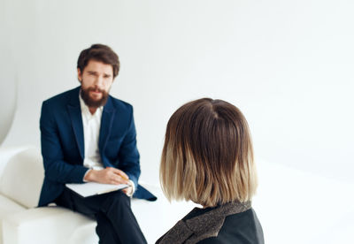 Side view of business colleagues standing against white background